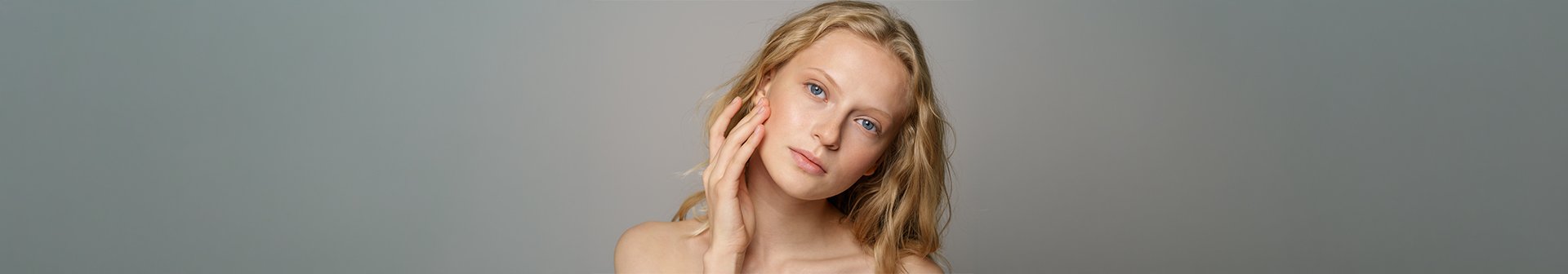 Kobieta o niebieskich oczach i falowanych blond włosach