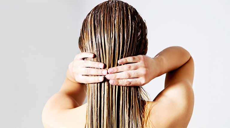 Widoczna z tyłu kobieta z prostymi włosami blond z nałożoną maską koloryzującą