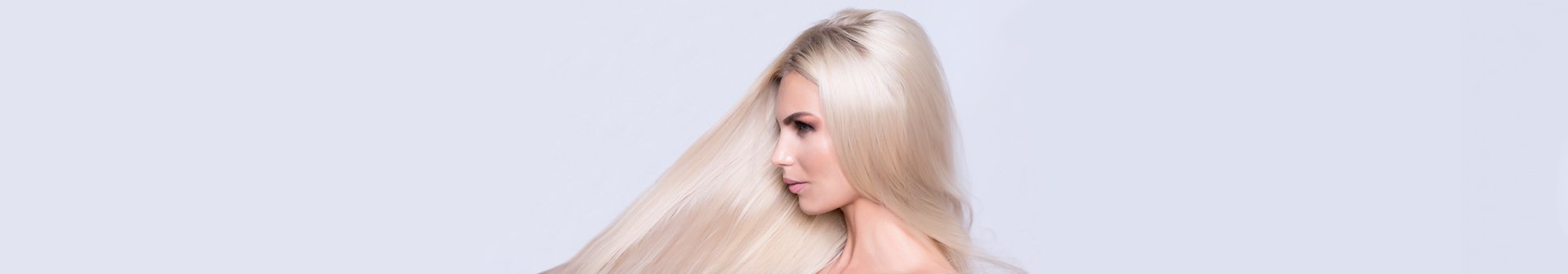 Boczny profil blondynki o platynowych, długich włosach, jasne tło