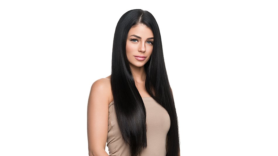 Kobieta z czarnymi, długimi, prostymi włosami na jasnym tle.