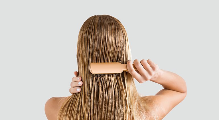 Kobieta rozczesująca włosy podczas pielęgnacji włosów