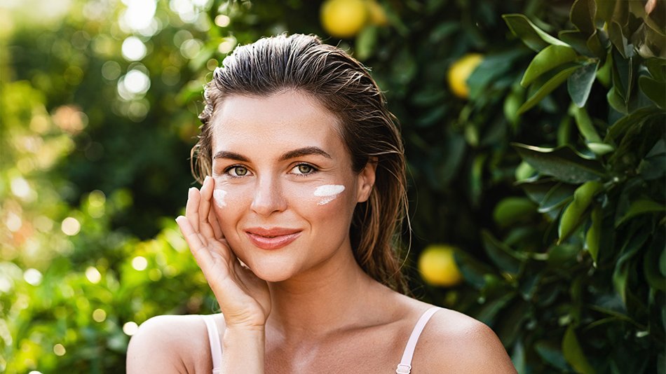 dziewczyna nakładająca na skórę twarzy krem z filtrem SPF