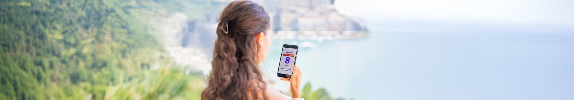 kobieta sprawdzająca indeks UV w trakcie wakacji