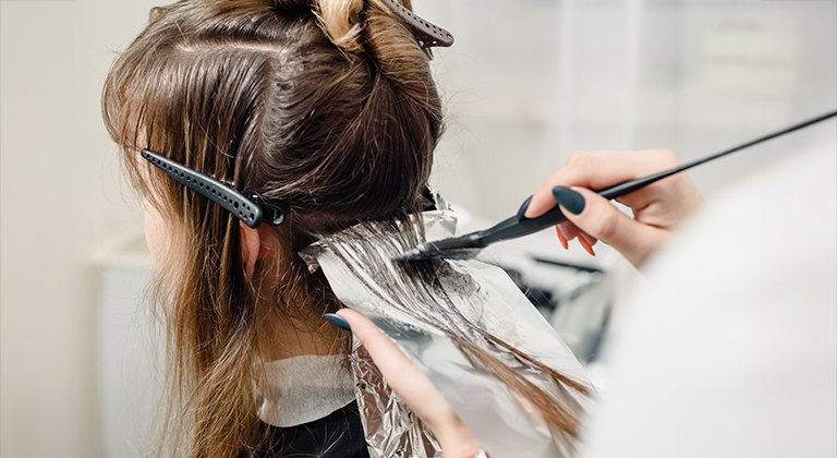 Kobieta podczas profesjonalnej koloryzacji włosów.