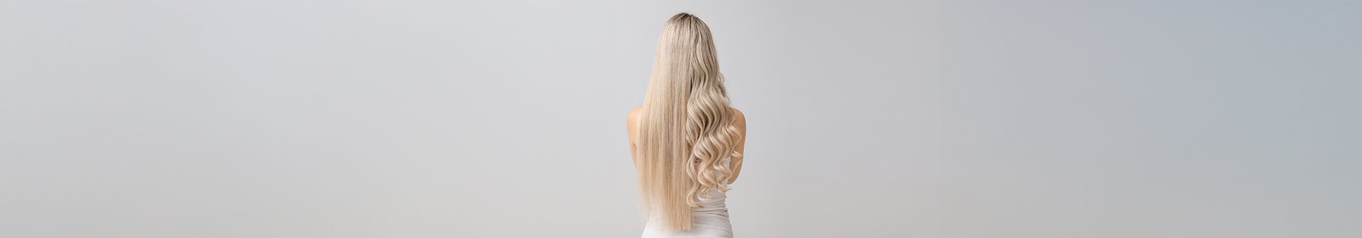 Kobieta stojąca tyłem, z wydzielonymi włosami na środku na proste i falowane