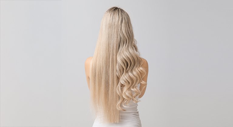 Kobieta stojąca tyłem, z wydzielonymi włosami na środku na proste i falowane
