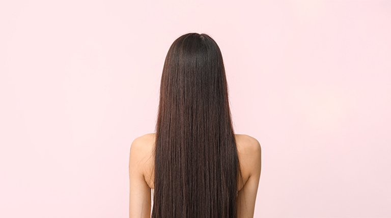 Widoczna z tyłu kobieta z długimi, prostymi brązowymi włosami