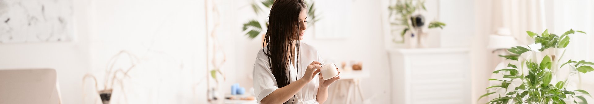 Kobieta z odkręconym słoiczkiem maski do włosów