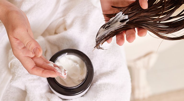 Kobieta od tyłu z odżywką na mokrych włosach