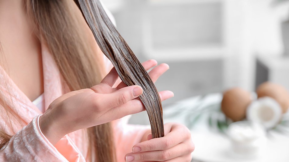 Kobieta nakłada maskę na pasmo włosów