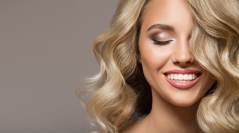 Kobieta z falowanymi włosami ufarbowanymi na blond