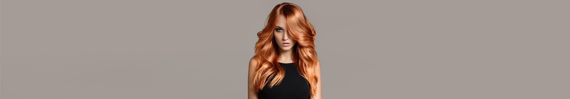 Kobieta z długimi falowanymi włosami zafarbowanymi na jasny rudy