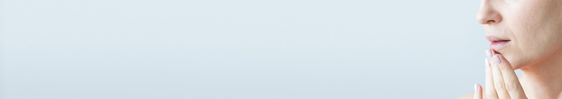 zdjęcie kobiety dotykającej podbródka na jasnoniebieskim tle