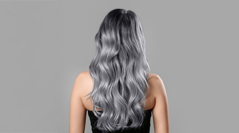 Widoczna z tyłu kobieta o intensywnie srebrnych, falowanych włosach
