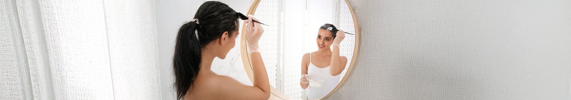 Kobieta przed lustrem nakładająca toner na włosy