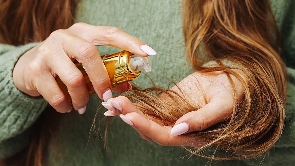 Kobieta nakłada serum na włosy.