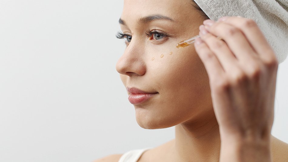 kobieta aplikująca serum do twarzy