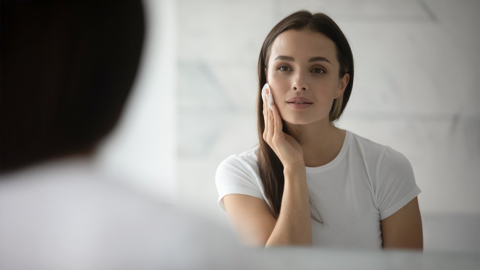 kobieta oczyszczająca skórę twarzy