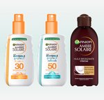 Trzy butelki Garnier Ambre Solaire Invisible Protect do ochrony przeciwsłonecznej, na jasnym tle