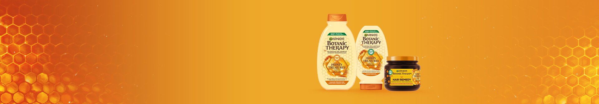 Trzy produkty Garnier Botanic Therapy Honey Treasures (szampon, odżywka, maska), na pomarańczowym tle