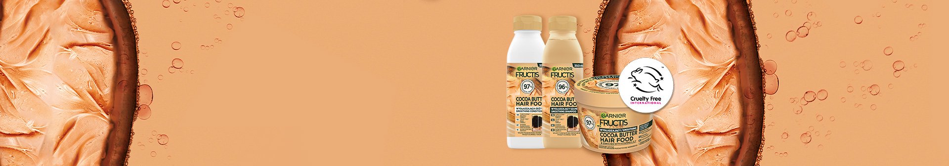 Trzy produkty Garnier Fructis Cocoa Butter Hair Food, na brzoskwiniowo-pomarańczowym tle