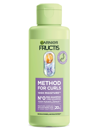 Jasnozielona butelka Garnier Fructis Curly z fioletową etykietą i grafiką składnika, na białym tle