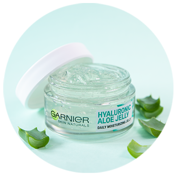 Otwarty słoik Garnier Hyaluronic Aloe Jelly z przezroczystym żelem, obok plasterki aloesu Otwarty słoik Garnier Hyaluronic Aloe Jelly z przezroczystym żelem, obok plasterki aloesu