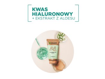 Tubka Garnier BB Cream wśród naczynek z zielonym żelem, aloesem i pudrem, na jasnym tle