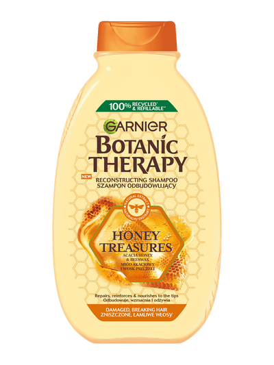 Żółta butelka szamponu Garnier Botanic Therapy z motywem miodu, na białym tle