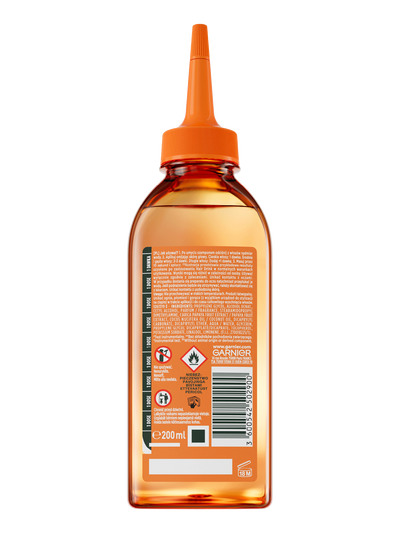 Bursztynowy płyn w przezroczystej butelce Garnier Fructis z pomarańczowym dziubkiem, na białym tle