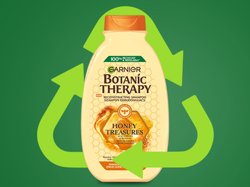 Butelka szamponu Garnier Botanic Therapy Honey Treasures w symbolu recyklingu, na ciemnozielonym tle
