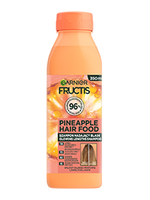 Pomarańczowa butelka szamponu Garnier Fructis Pineapple Hair Food z motywem ananasa, na białym tle
