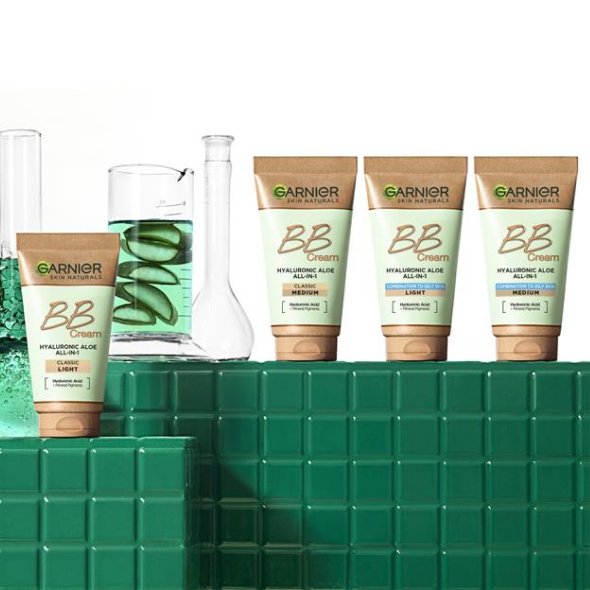 Cztery tubki Garnier BB Cream na zielonych kafelkach, obok zlewki z zielonym płynem i aloesem Cztery tubki Garnier BB Cream na zielonych kafelkach, obok zlewki z zielonym płynem i aloesem