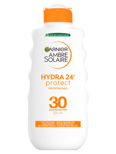 Biała butelka mleczka ochronnego Garnier Ambre Solaire z pomarańczowym kapslem, na białym tle