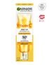 Wysoka, smukła butelka Garnier Vitamin C Daily UV z plasterkami pomarańczy i opisem produktu