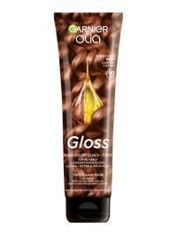 Tubka Garnier Olia Gloss z falowanymi, miedziano-brązowymi włosami i kroplą olejku, na ciemnym tle