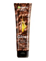 Tubka Garnier Olia Gloss z falowanymi, miedziano-brązowymi włosami i kroplą olejku, na ciemnym tle