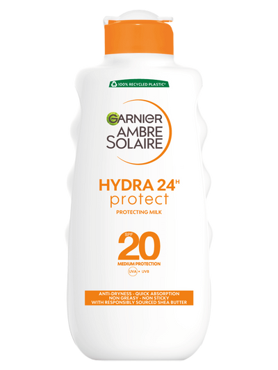 Biała butelka mleczka Garnier Ambre Solaire Hydra 24h Protect SPF 20 z pomarańczowym kapslem, na czarnym tle