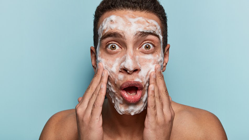 mężczyzna myjący twarz